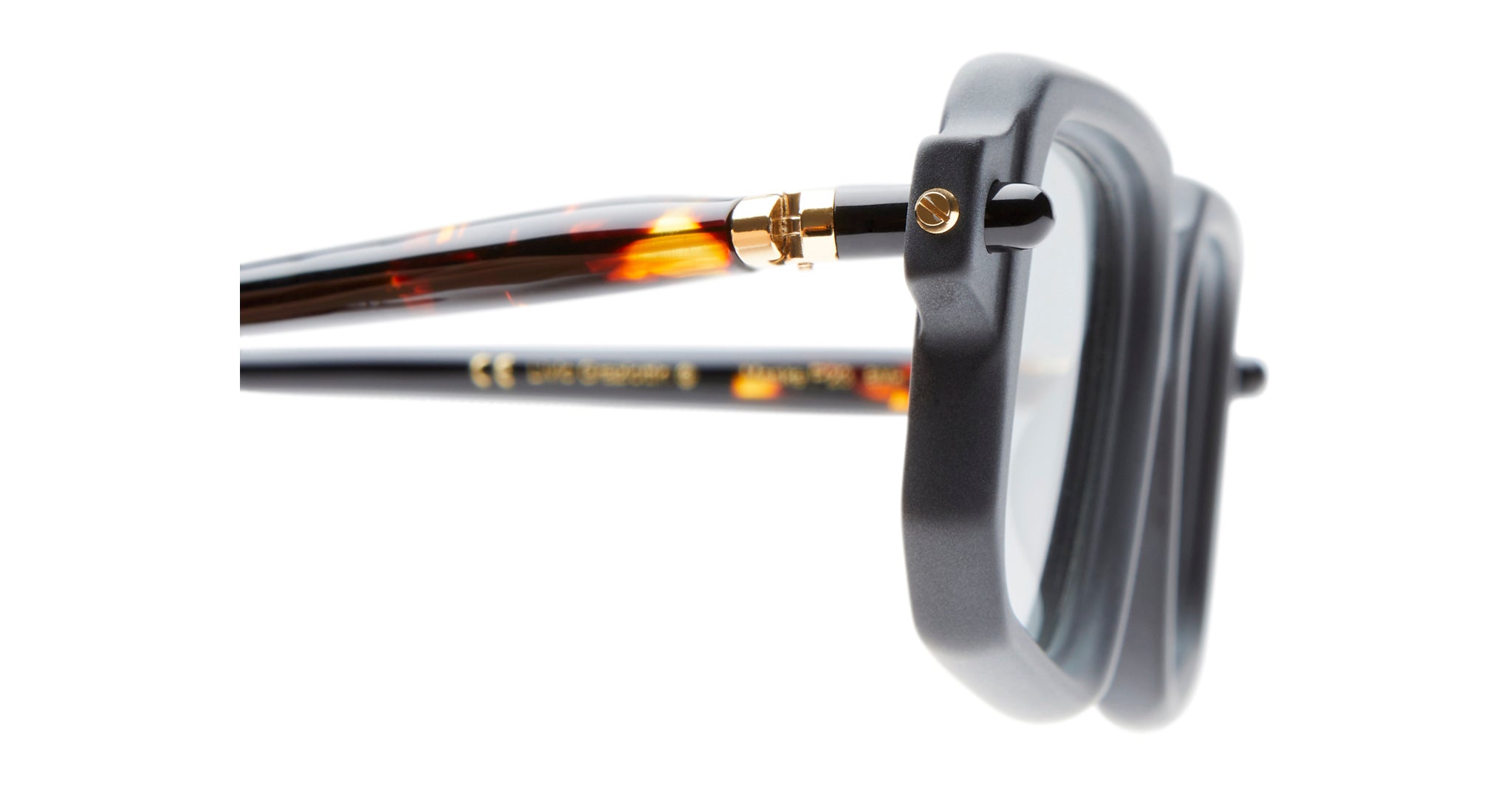 Close-up of the Kuboraum P23 eyeglasses featuring a black square frame, gold hinge, and tortoiseshell-patterned arms, shown from the side and front against a white background.