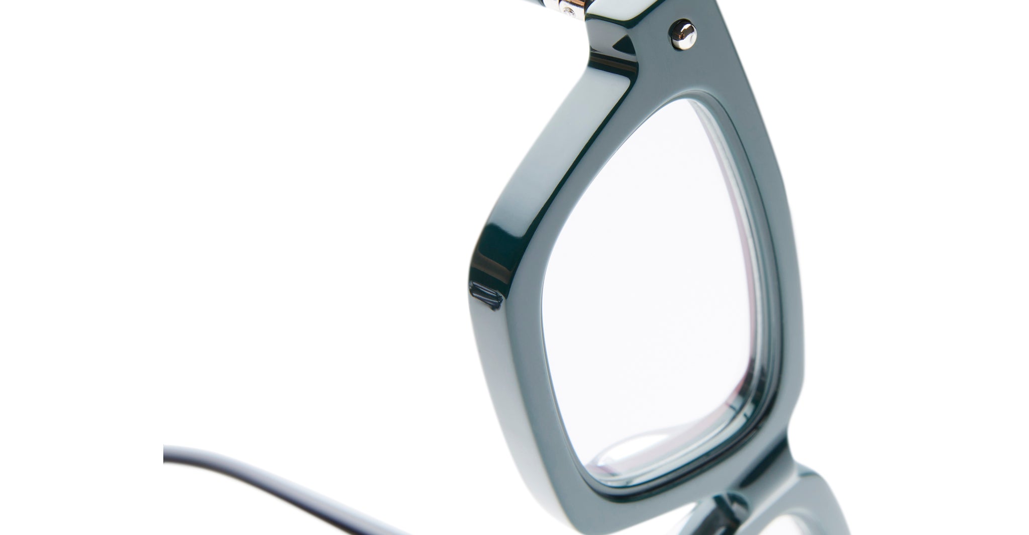 Close-up of the side and lens of the Kuboraum P25 eyeglasses, featuring thick, glossy dark green frames. Set against a white background, only part of the frame and lens is visible.