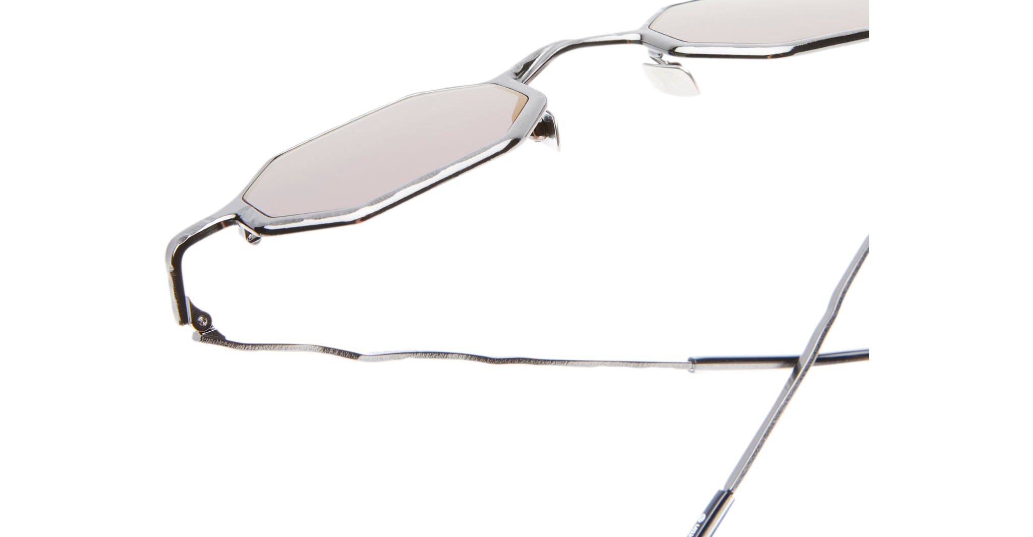 Close-up of Kuboraum Z19 sunglasses featuring metal frames, angular geometric shapes, and light-tinted lenses. The jagged texture of the arms is highlighted against a white background.