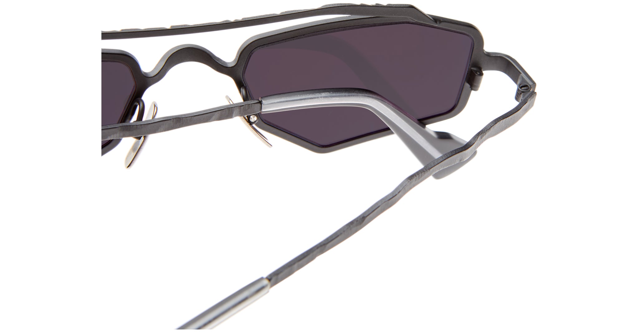 Close-up of Kuboraum Z23 sunglasses featuring an angular, matte black frame with a unique textured design, dark lenses, and thin metallic temples against a white background.