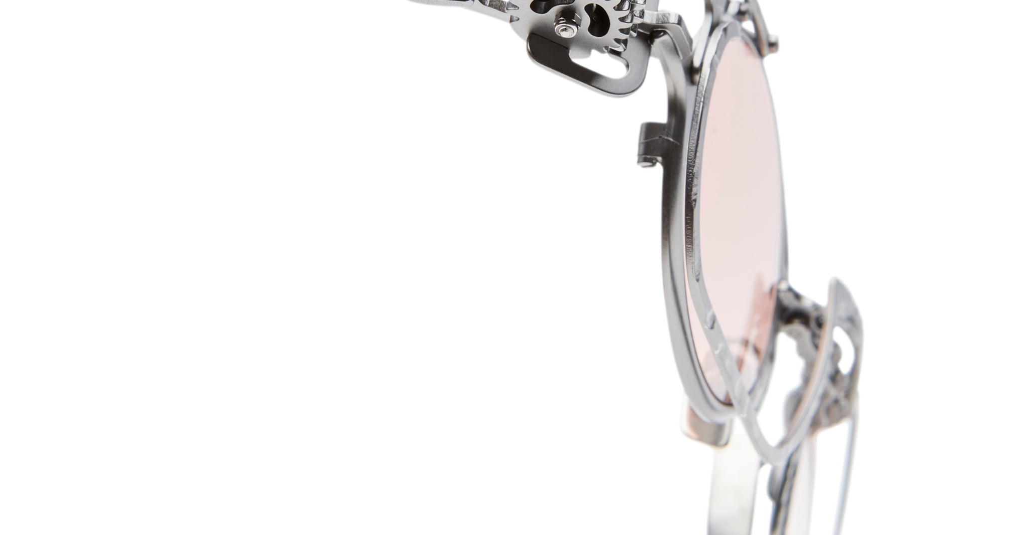 Close-up of Kuboraum Z50 round sunglasses with light pink lenses and intricate metal detailing on the frame, featuring ornate accents near the temple, shown against a white background.