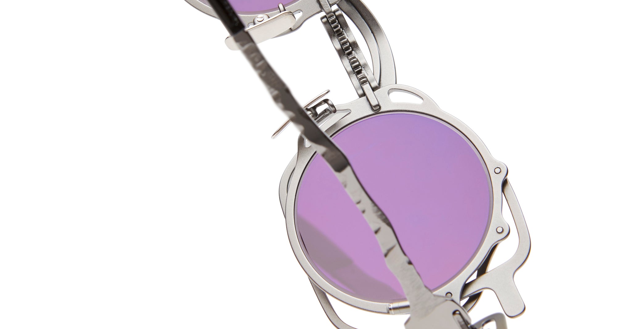 Close-up of KUBORAUM Z50 round sunglasses with lavender lenses and a jagged metal bar detail along the frame.