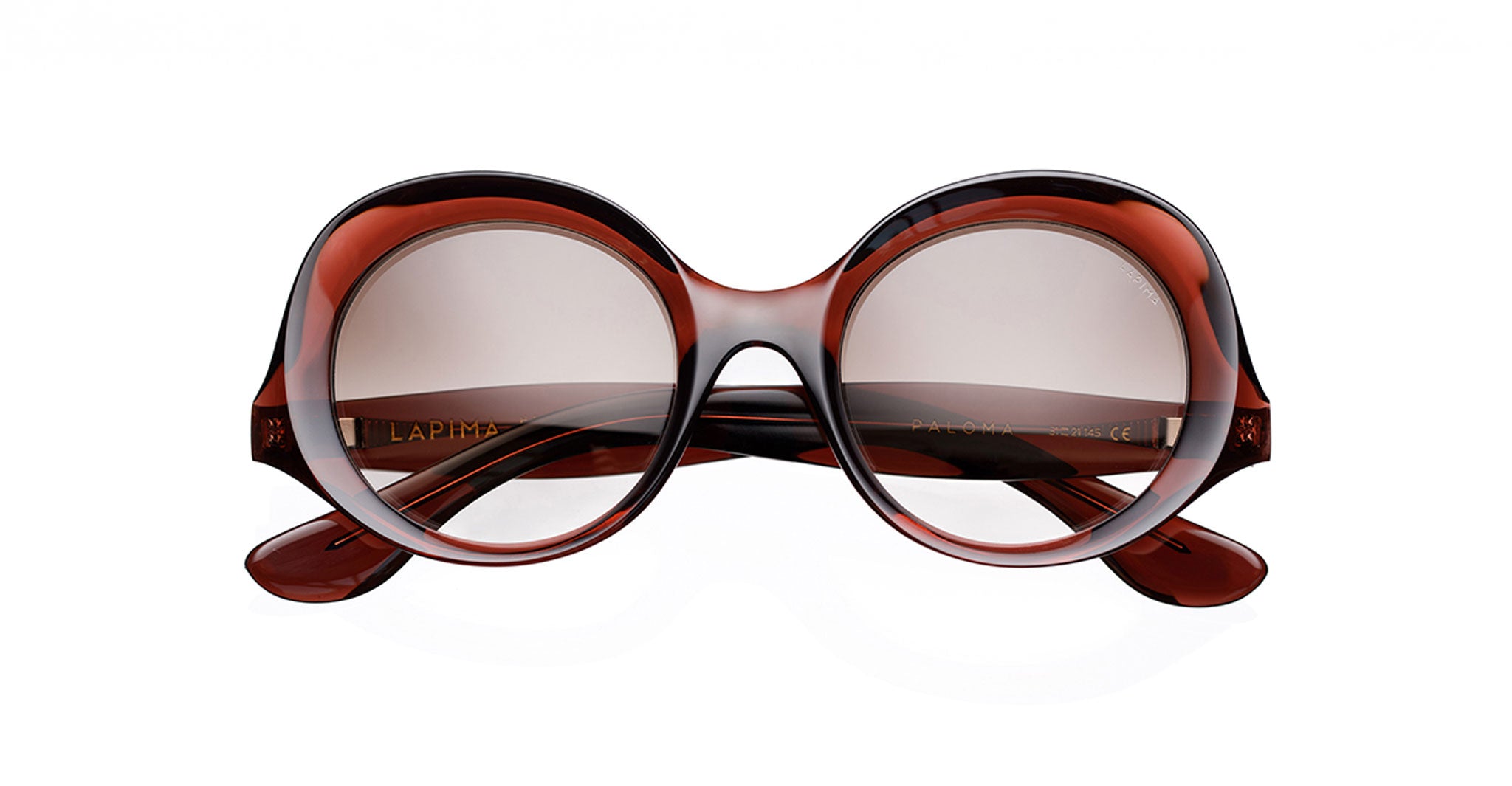Lapima Paloma round, oversized sunglasses, handcrafted in Brazil with thick, glossy brownish-red Italian acetate frames and dark tinted lenses, shown against a white background.