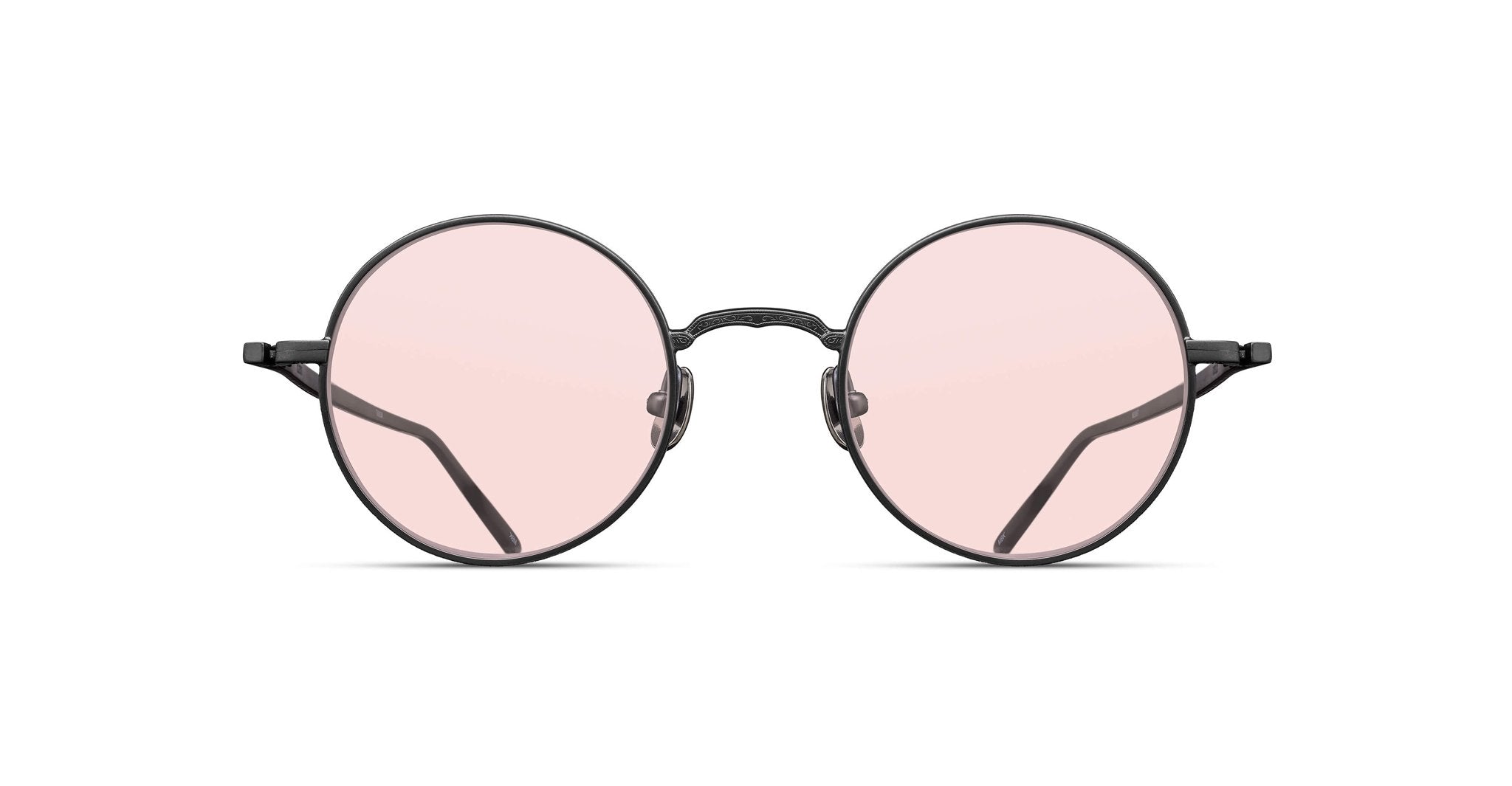 The Matsuda M3087 features round eyeglasses with thin black frames and light pink tinted lenses, shown from the front against a white background.