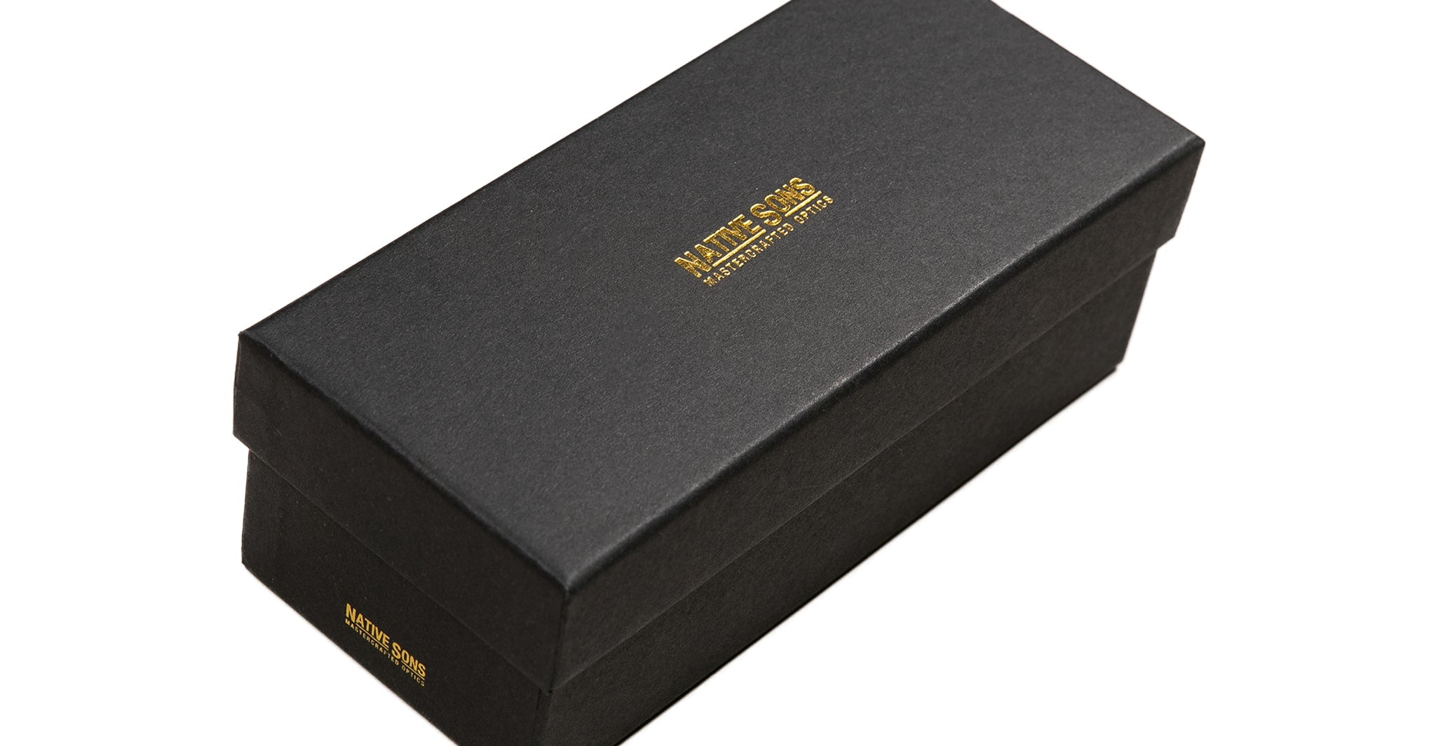 A rectangular black box with a lid, featuring gold embossed text reading MATTIS SANS on the top and side, is set against a white background—ideal for presenting Native Sons Casinola x Native Sons “The E’s” (The Eddie) eyewear.