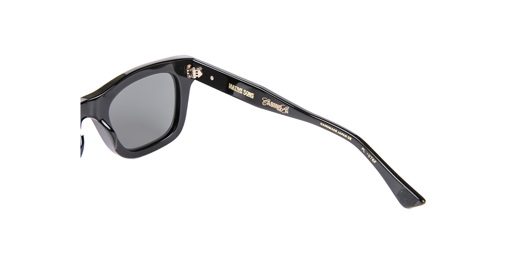 Close-up of Native Sons Casinola x Native Sons “The E’s” (The Eddie) eyewear arm in Takiron acetate, featuring gold engravings—a cartoon face, stylized text, and product details—on these unique Wellington sunglasses.