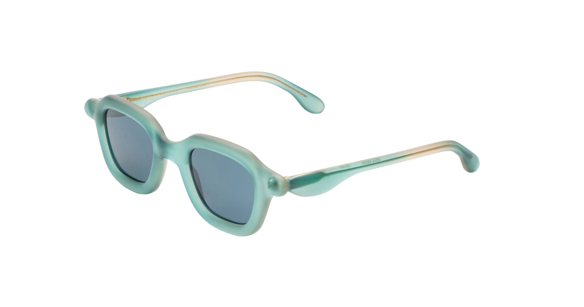 A pair of Paloceras sunglasses with a translucent mint green frame and light blue lenses, featuring a subtle gold accent on the inner temples.