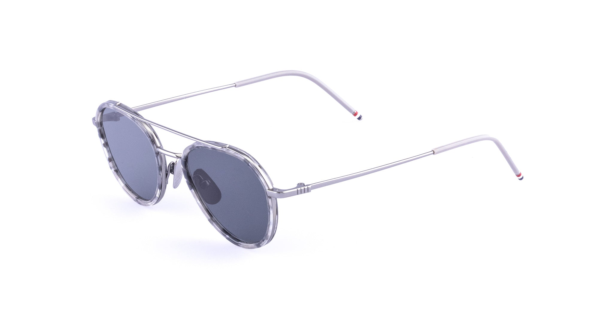 Round sunglasses with gray-tinted lenses, a clear marbled frame, and thin metal arms featuring small red and blue accents on the tips.