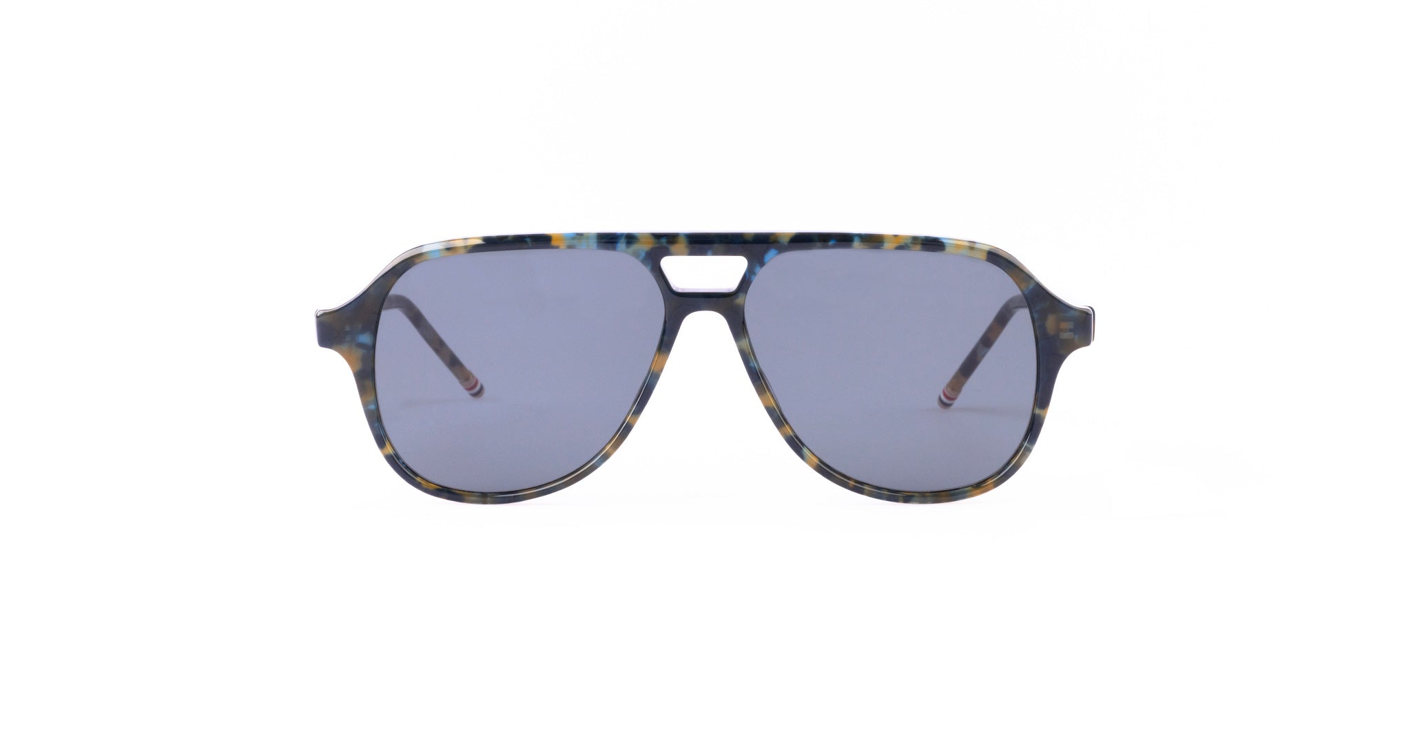 A pair of Thom Browne aviator sunglasses with blue-tinted lenses and a multicolored, tortoiseshell-style frame. The design features a straight top edge and a small cutout above the nose bridge.