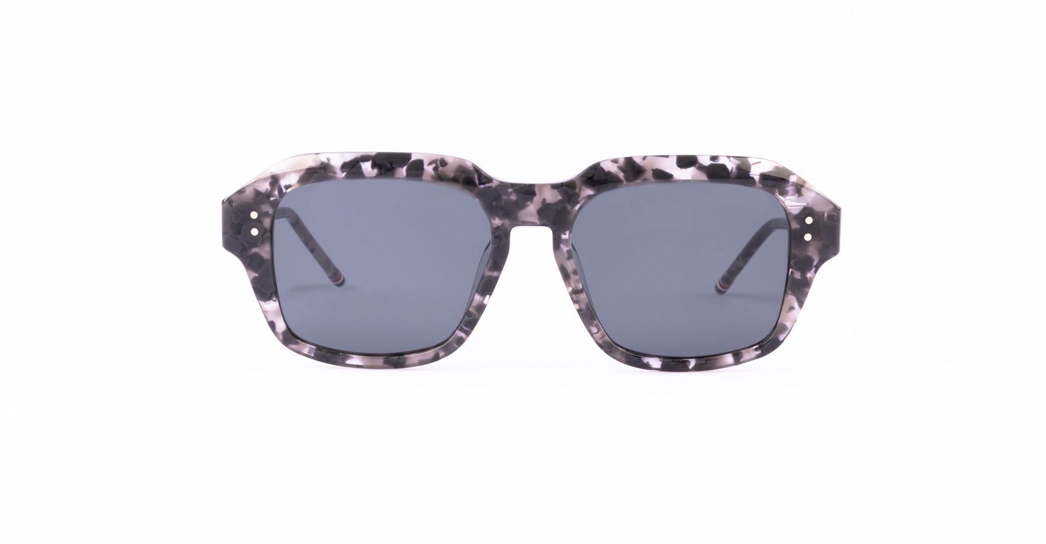 The Thom Browne 928 sunglasses feature a gray and black tortoiseshell pattern, thick rectangular frames, and dark lenses, displayed front-facing on a white background.