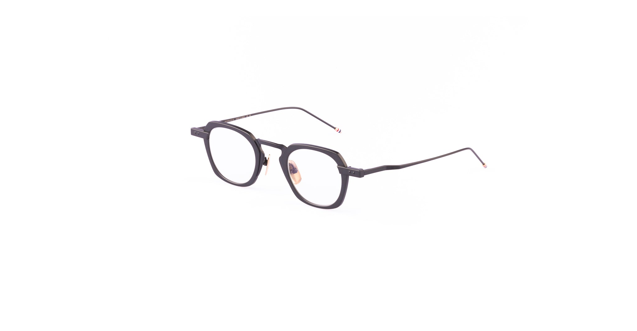 The Thom Browne 930 features black, rectangular eyeglasses with thin arms and clear lenses, shown on a white background.