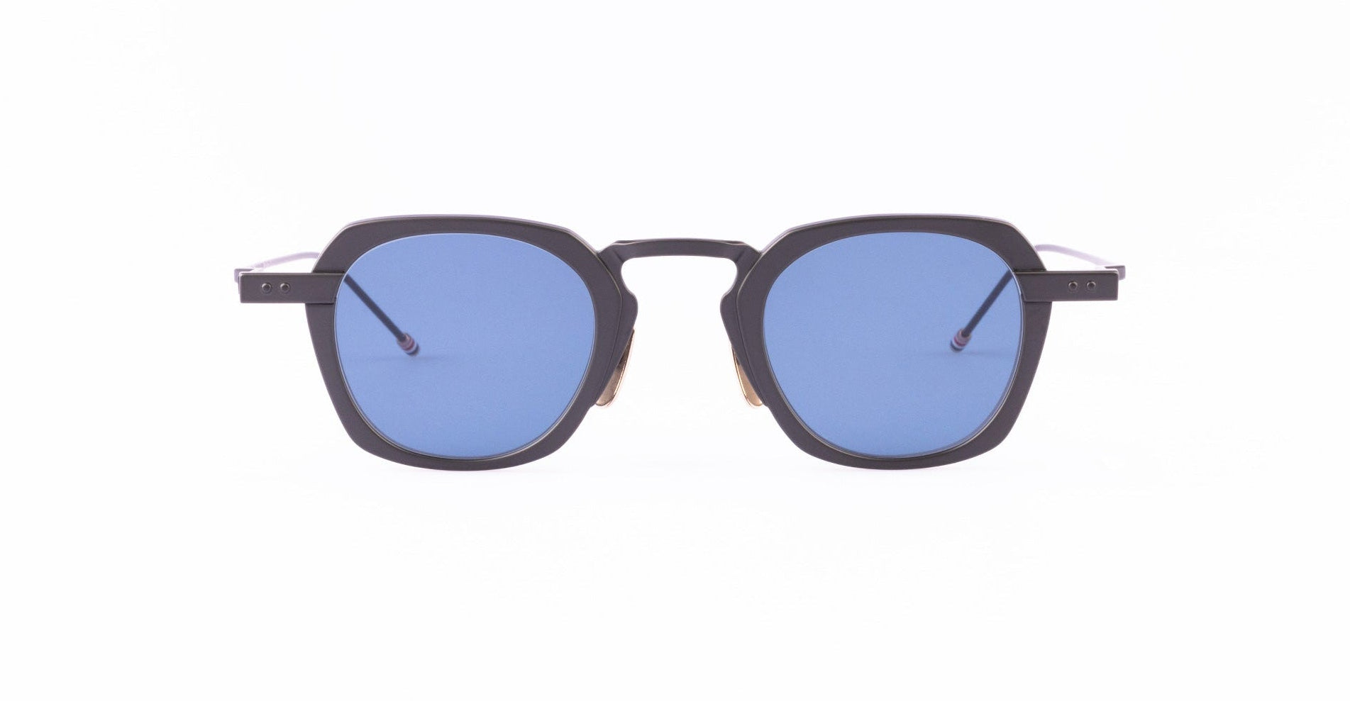 A pair of Thom Browne sunglasses with thick, black geometric frames and blue-tinted square lenses.
