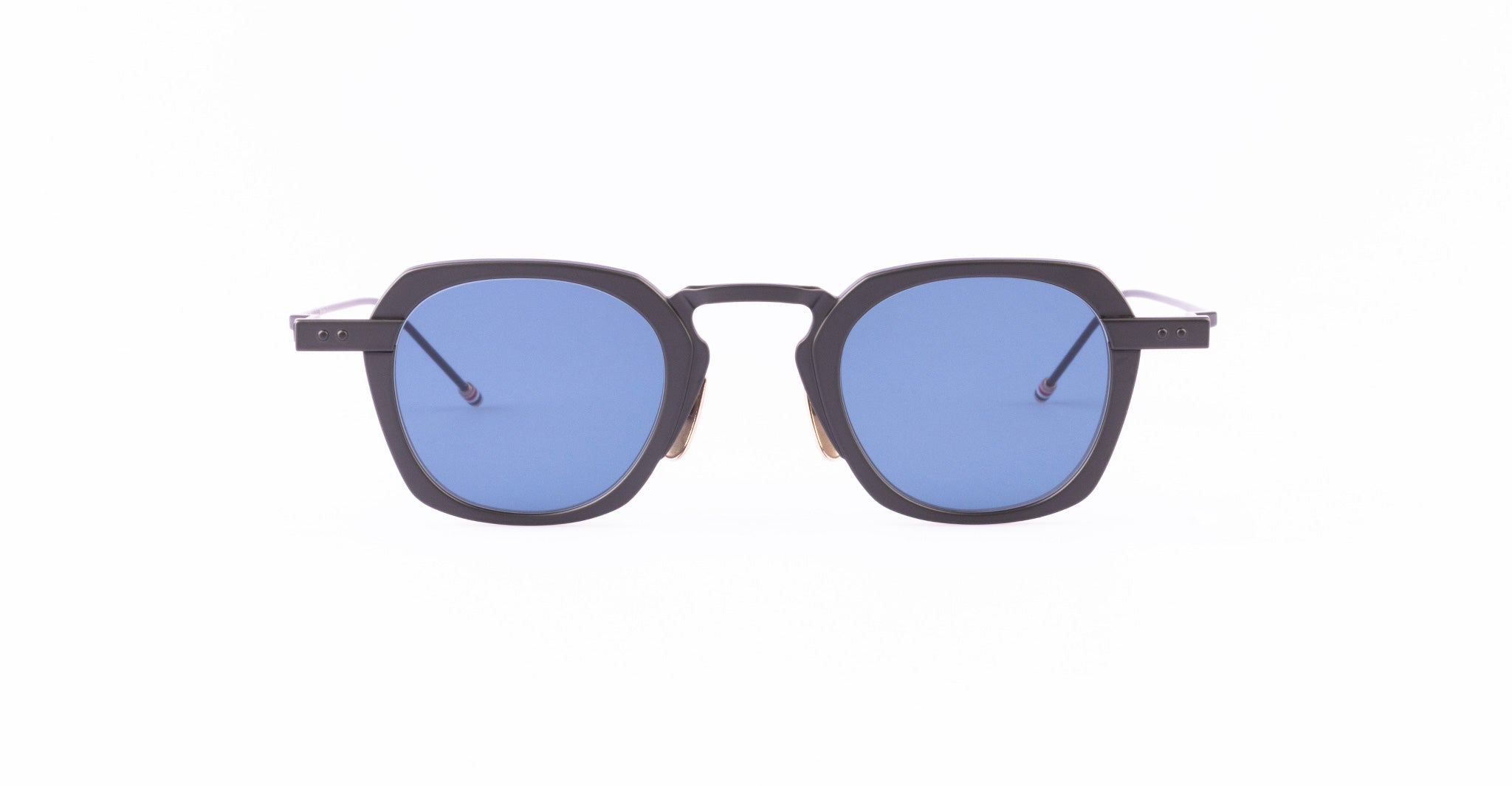 A pair of Thom Browne sunglasses with thick, black geometric frames and blue-tinted square lenses.