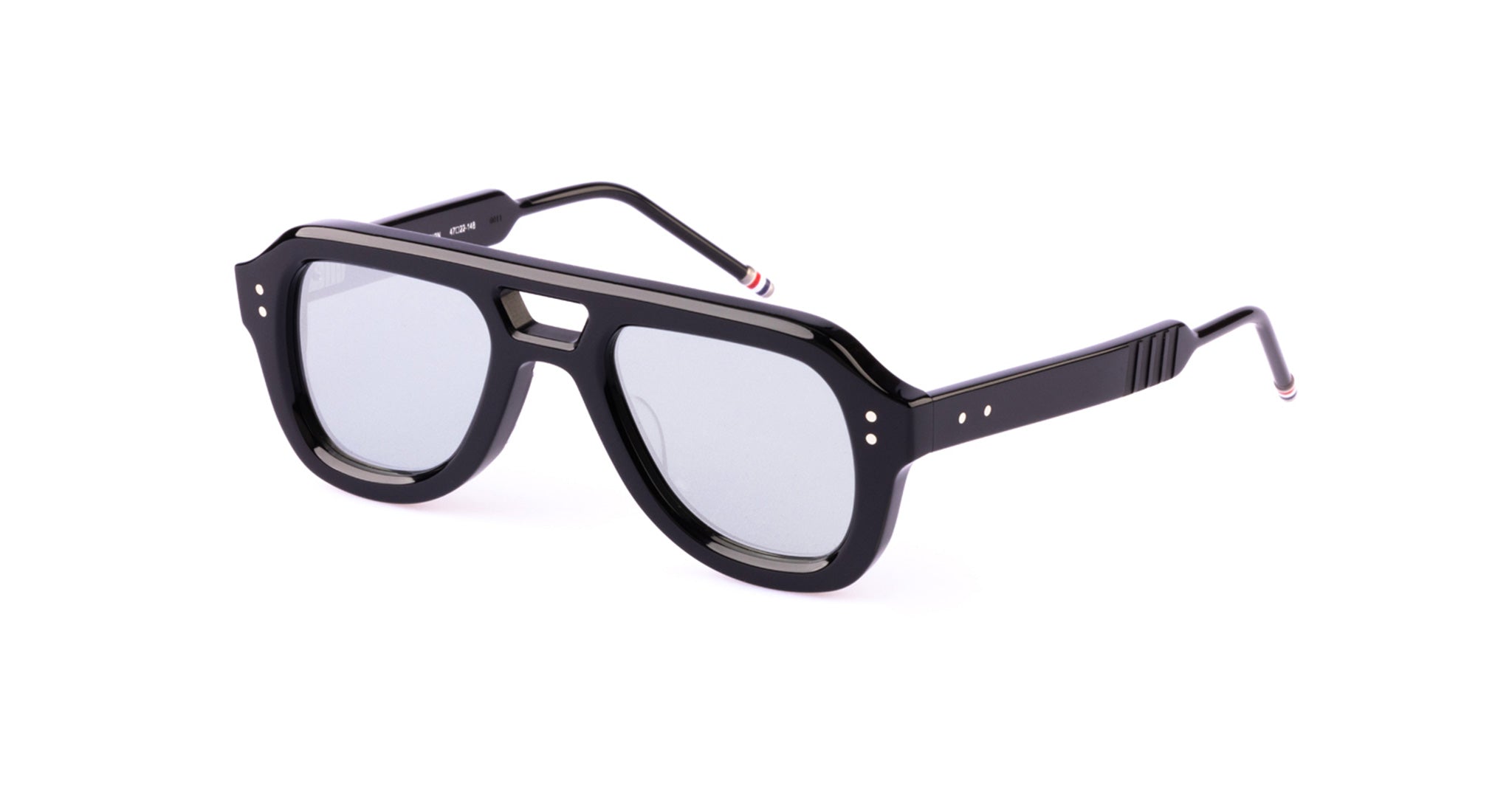 A pair of black, thick-rimmed Thom Browne aviator sunglasses with silver-tinted lenses, metal rivets on the corners, and striped detailing on the temple tips