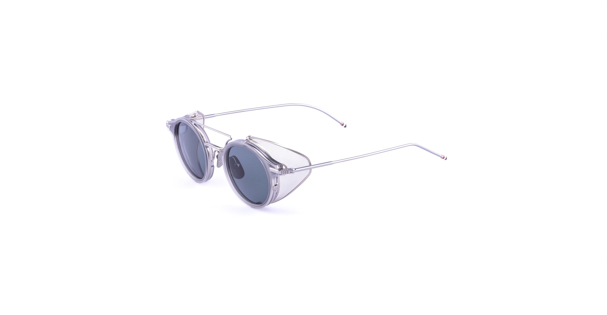The Thom Browne 804 features clear round frames, blue-tinted lenses, and slim silver arms, shown against a plain white background.