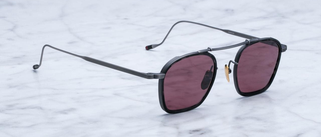 Jacques Marie Mage Baudelaire sunglasses with black frames and dark red lenses, front view.