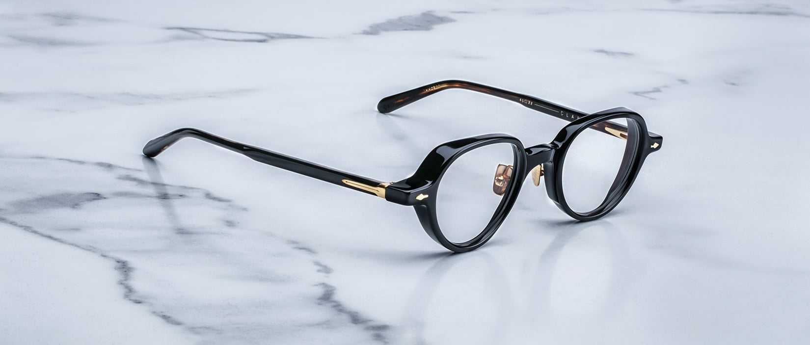 Jacques Marie Mage The Clark black round eyeglasses with gold accents, front view.