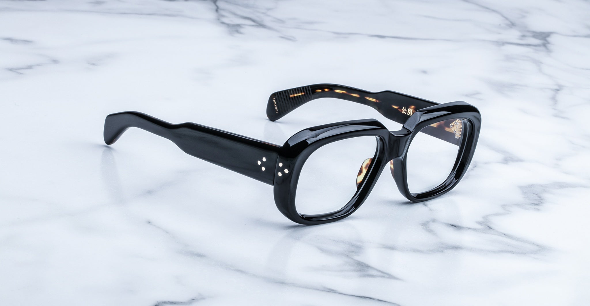 Jacques Marie Mage Kobo black rectangular eyeglasses, front view, displayed on a white marble surface.