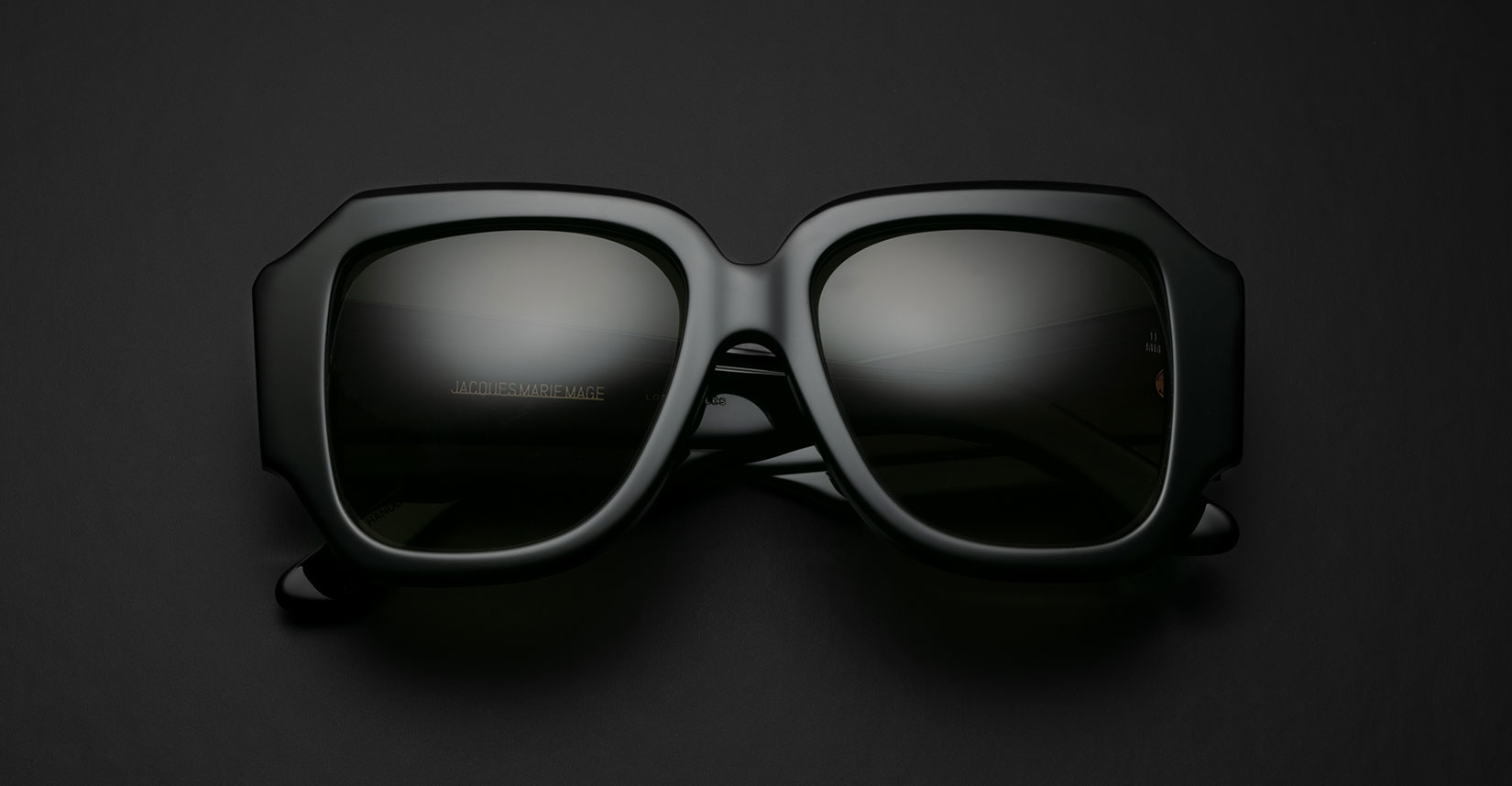 Jacques Marie Mage Gloria in black square frame sunglasses with dark lenses, front view.