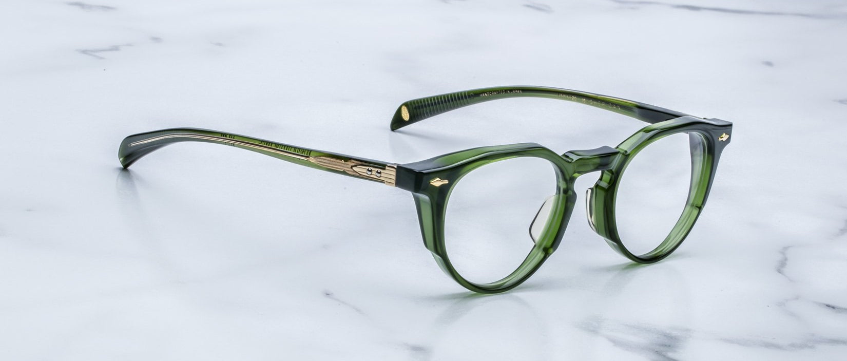 Jacques Marie Mage Sheridan in Rover, translucent green glasses with sculpted brow and gold arrowhead pins angled view