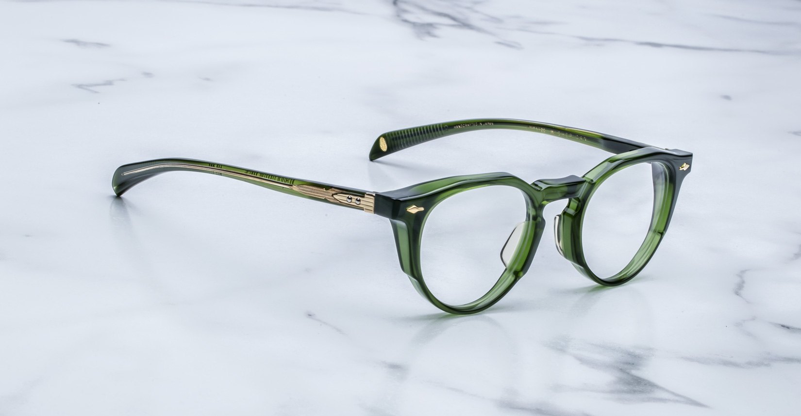 Jacques Marie Mage Sheridan in Rover, translucent green glasses with sculpted brow and gold arrowhead pins angled view