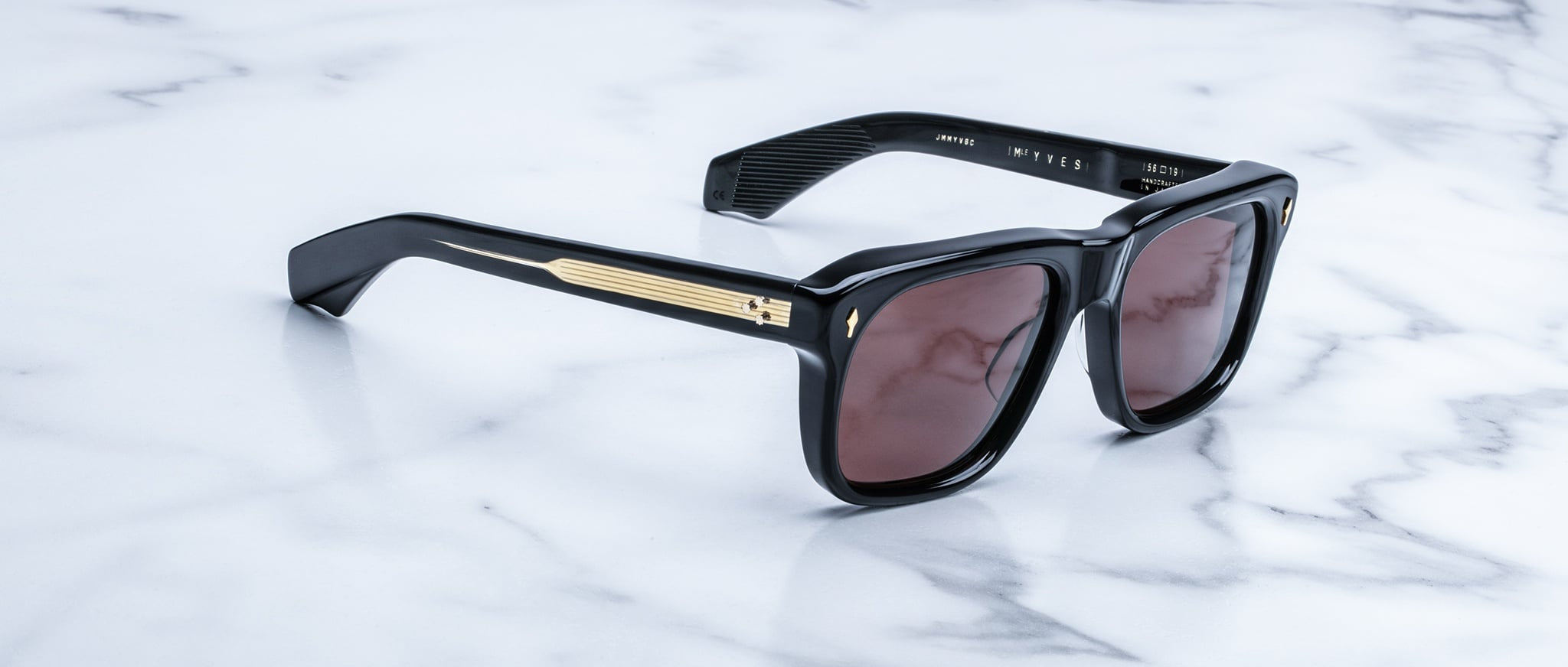 Jacques Marie Mage Yves sunglasses with gold accents and dark lenses, side angled view.