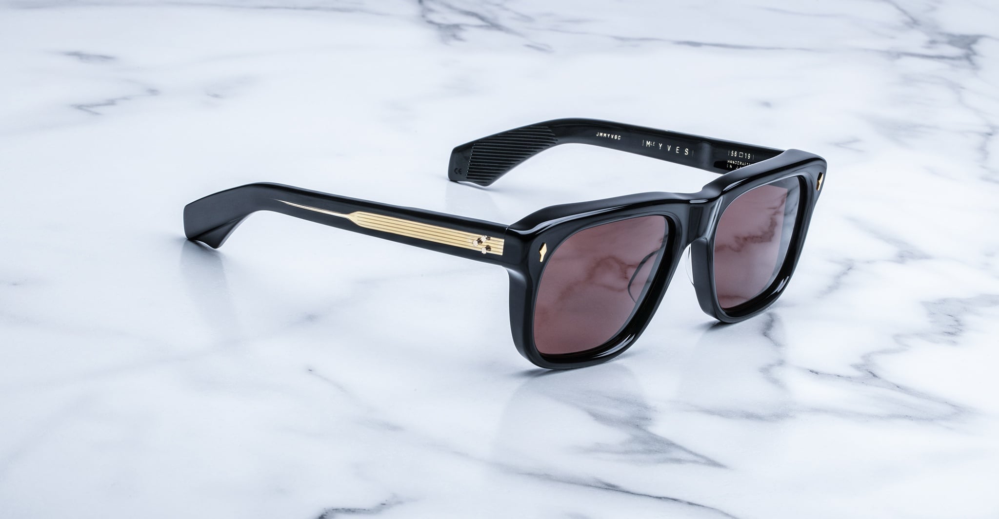 Jacques Marie Mage Yves sunglasses with gold accents and dark lenses, side angled view.