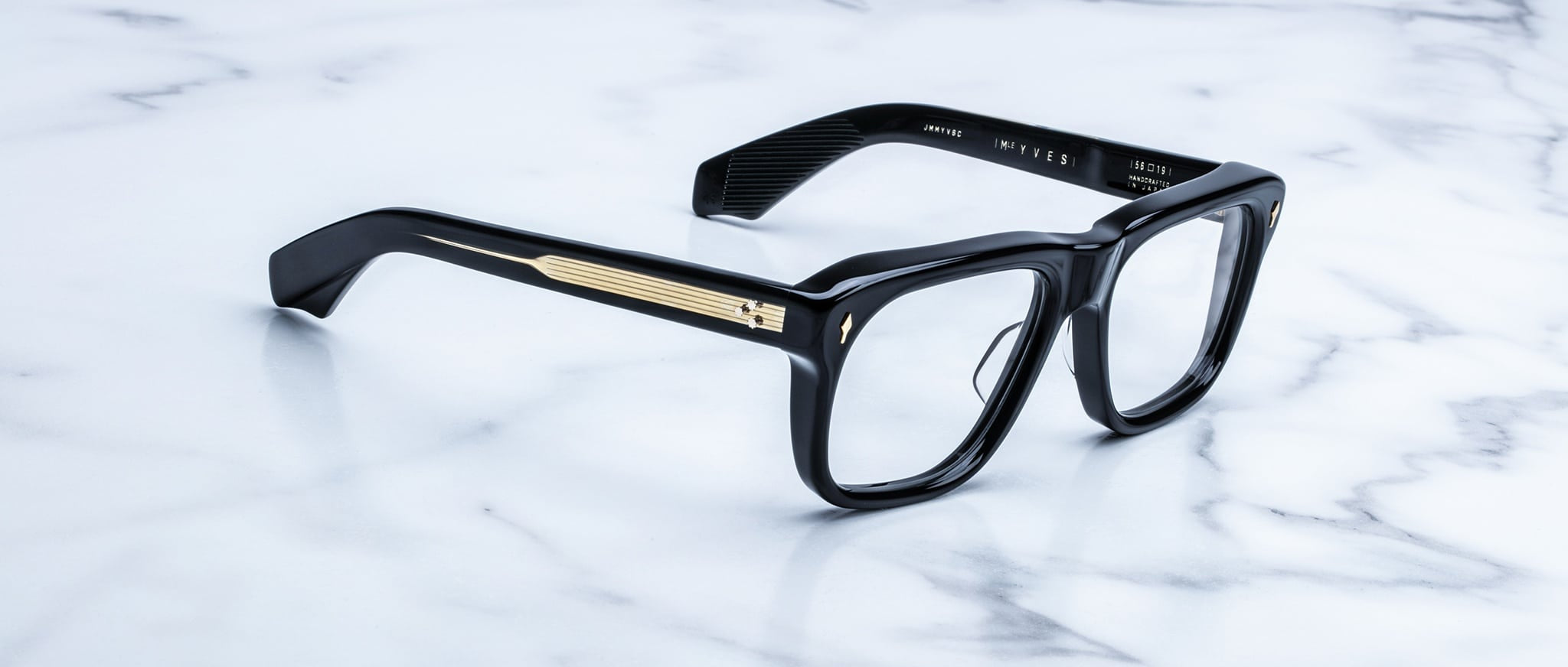 Jacques Marie Mage Yves black rectangular eyeglasses with gold temple detailing, top view.