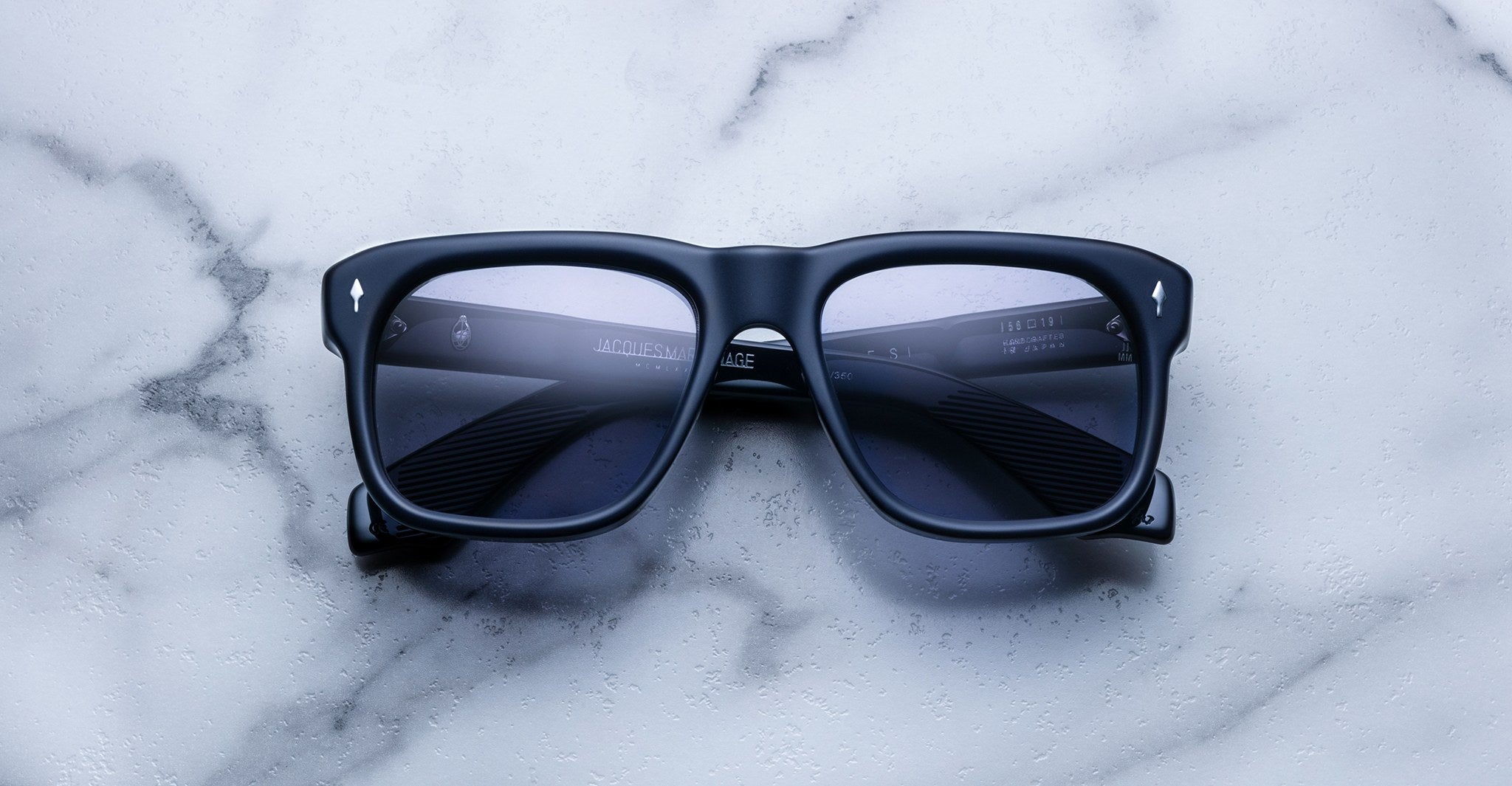 Jacques Marie Mage Yves black square-framed polarized sunglasses with dark lenses, top view.