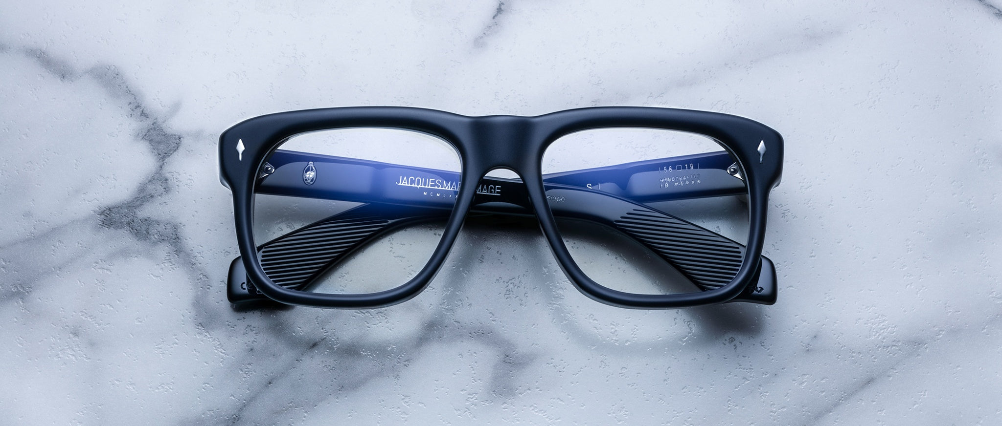 Jacques Marie Mage Yves black rectangular eyeglasses with blue accents, top view.