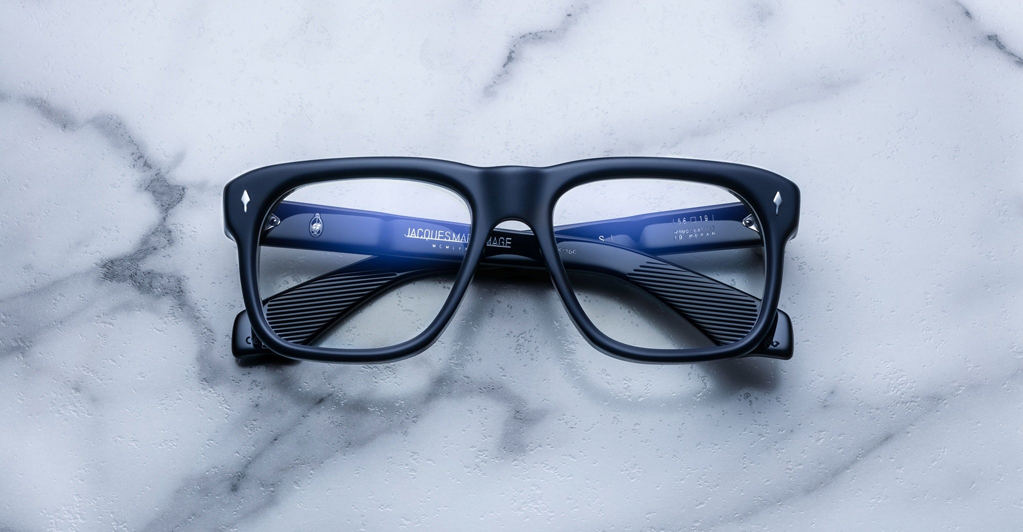 Jacques Marie Mage Yves black rectangular eyeglasses with blue accents, top view.