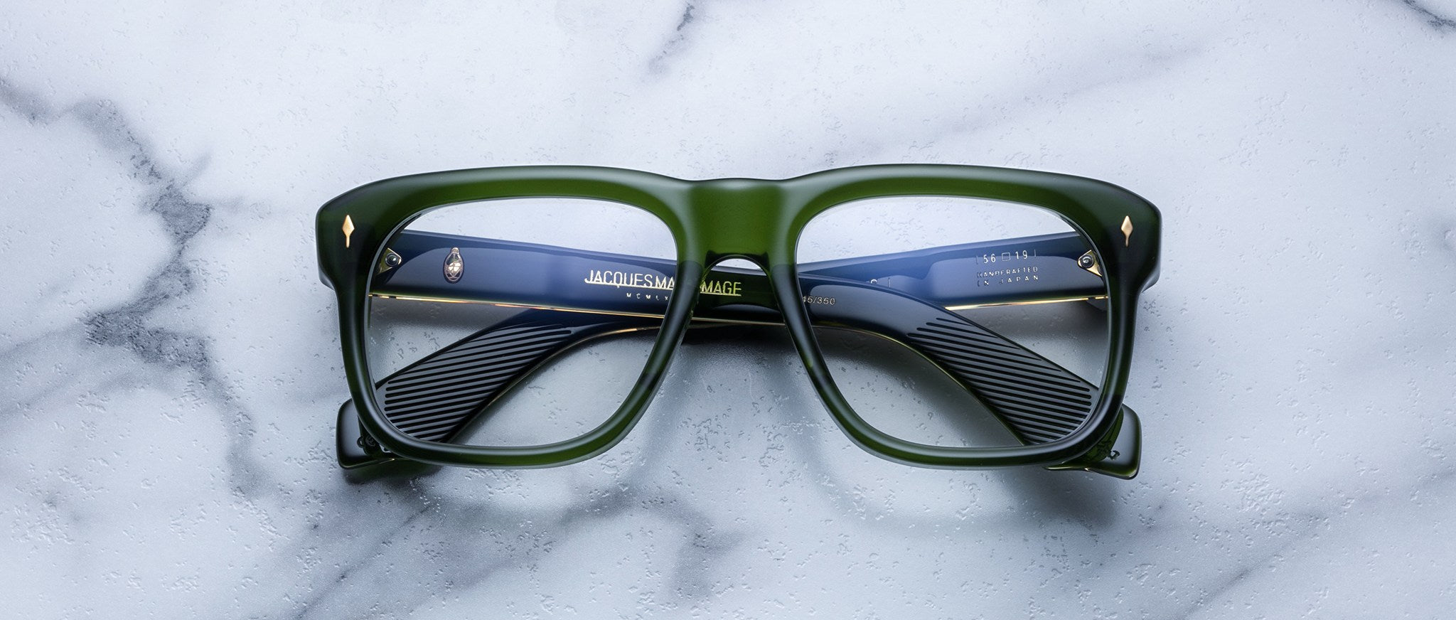 Jacques Marie Mage Yves green square eyeglasses with blue-patterned arms, top view.