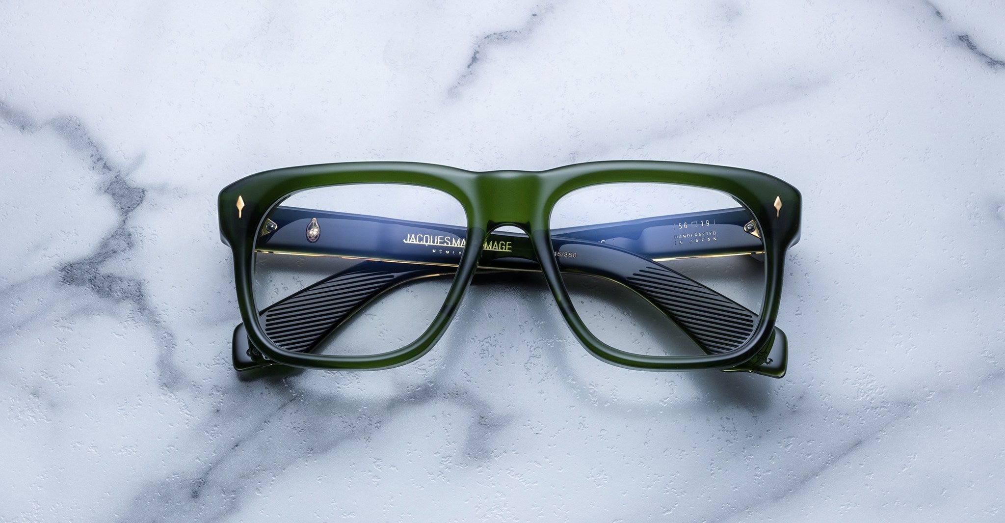 Jacques Marie Mage Yves green square eyeglasses with blue-patterned arms, top view.