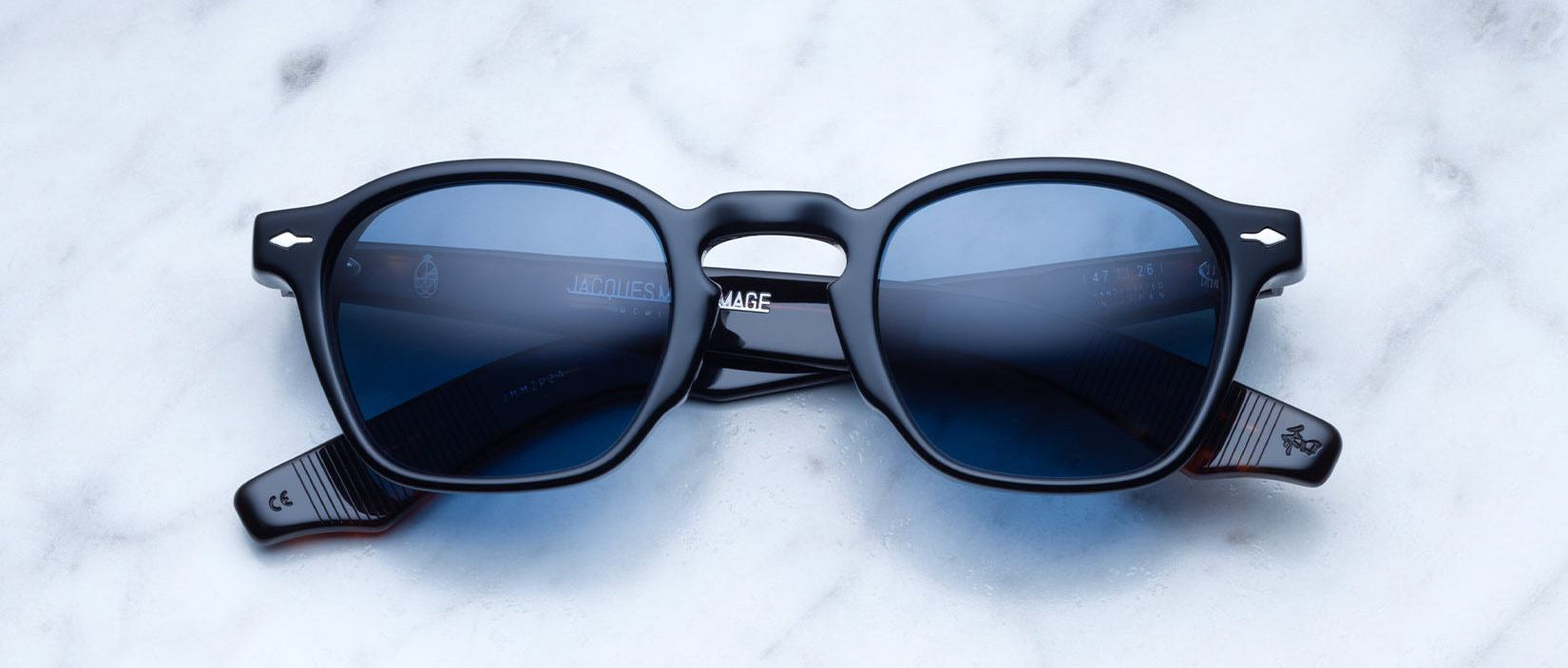Jacques Marie Mage Zephirin 47 sunglasses with black frames and blue lenses shown from above.