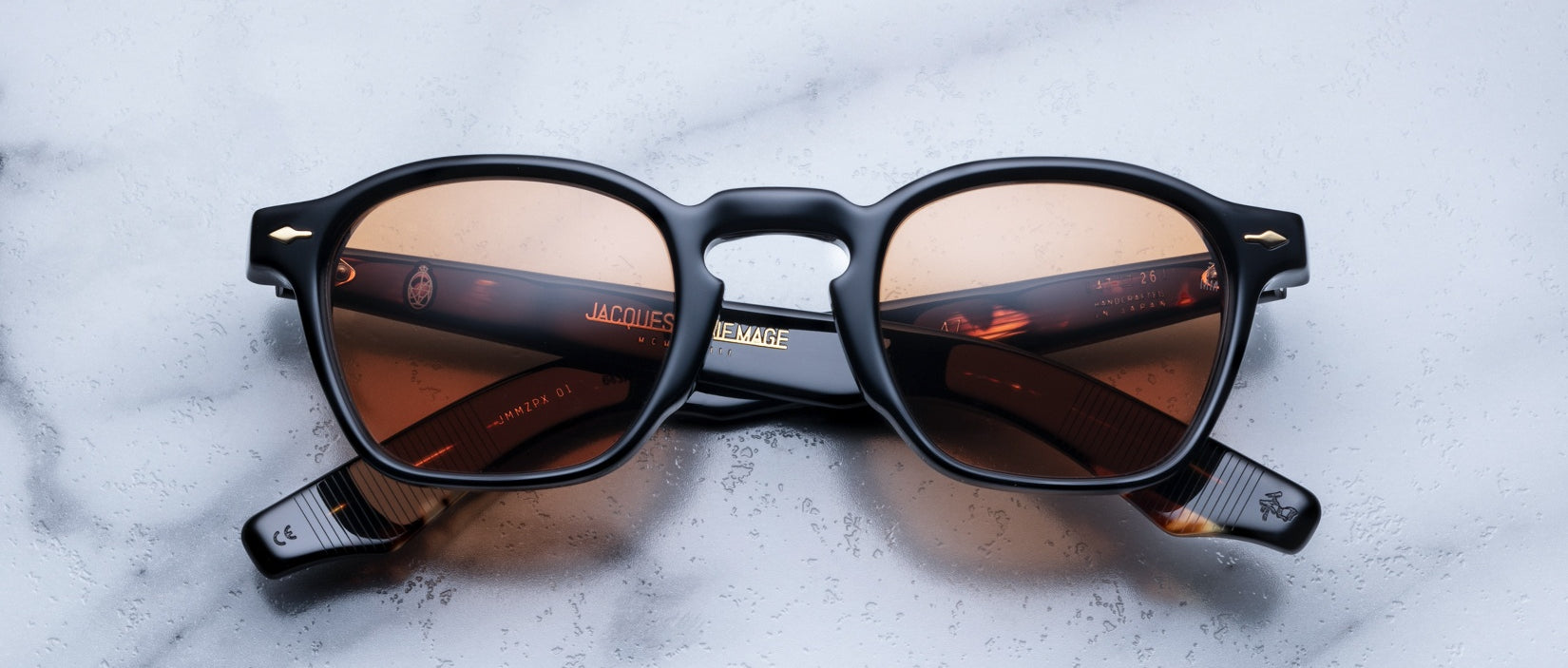 Jacques Marie Mage Zephirin 47 sunglasses with black frames and brown lenses, viewed from above.