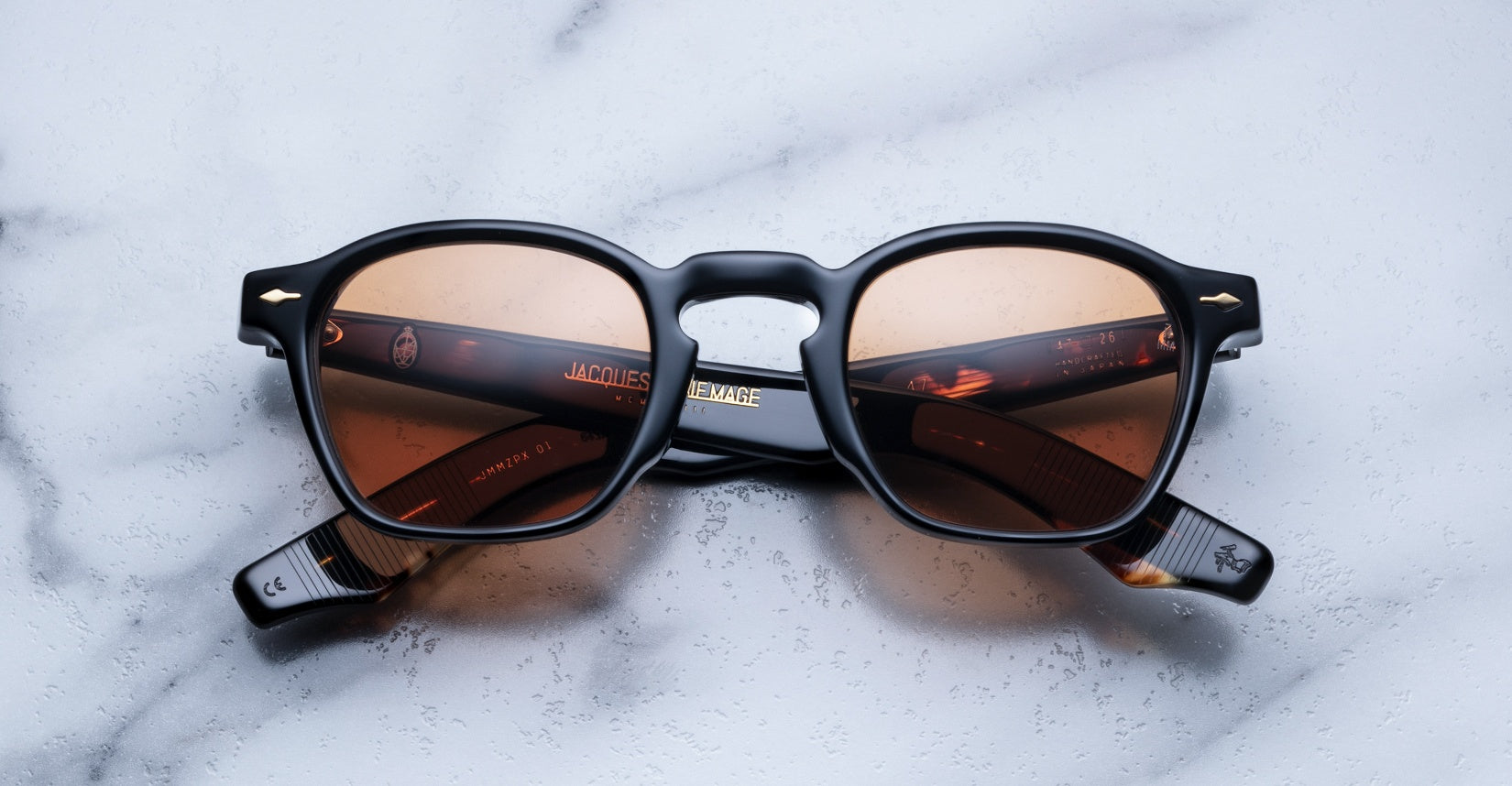 Jacques Marie Mage Zephirin 47 sunglasses with black frames and brown lenses, viewed from above.