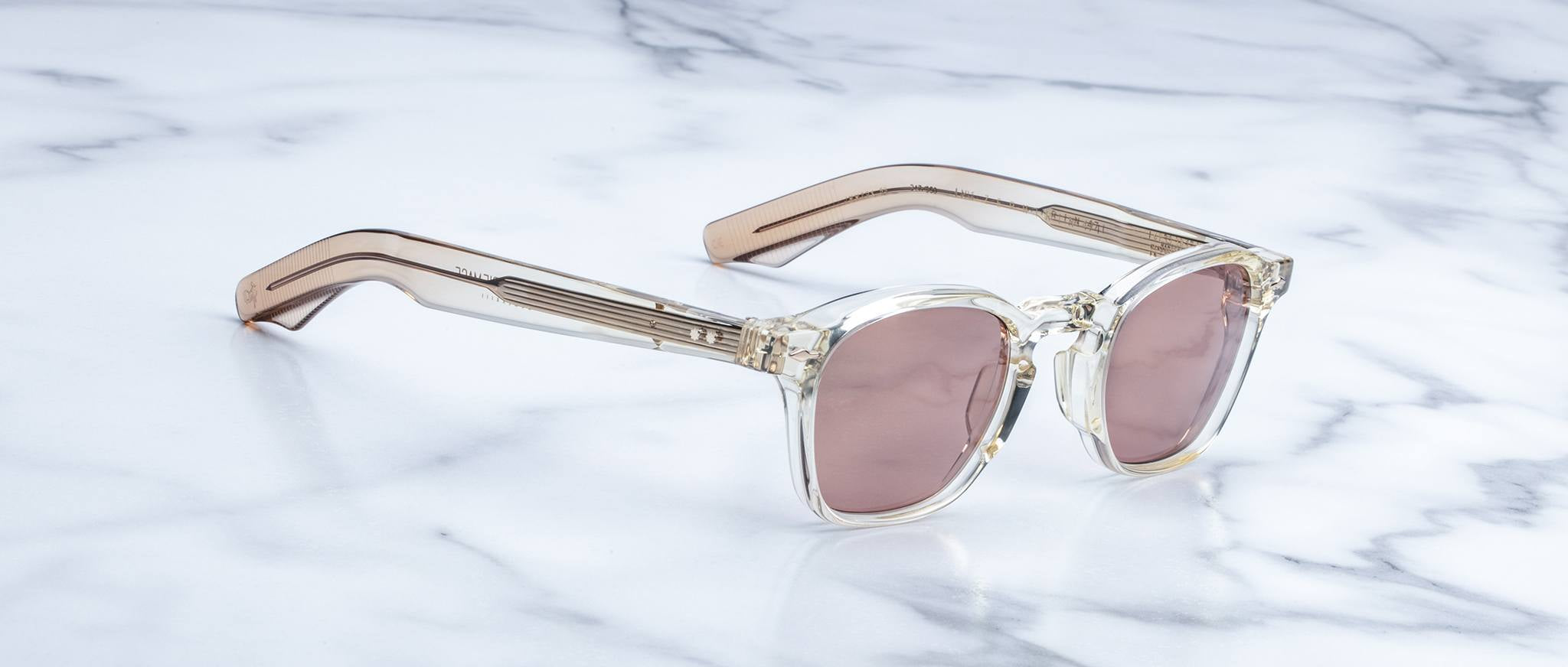 Jacques Marie Mage Zephirin 47 sunglasses with pink lenses and light brown temples, shown from above.