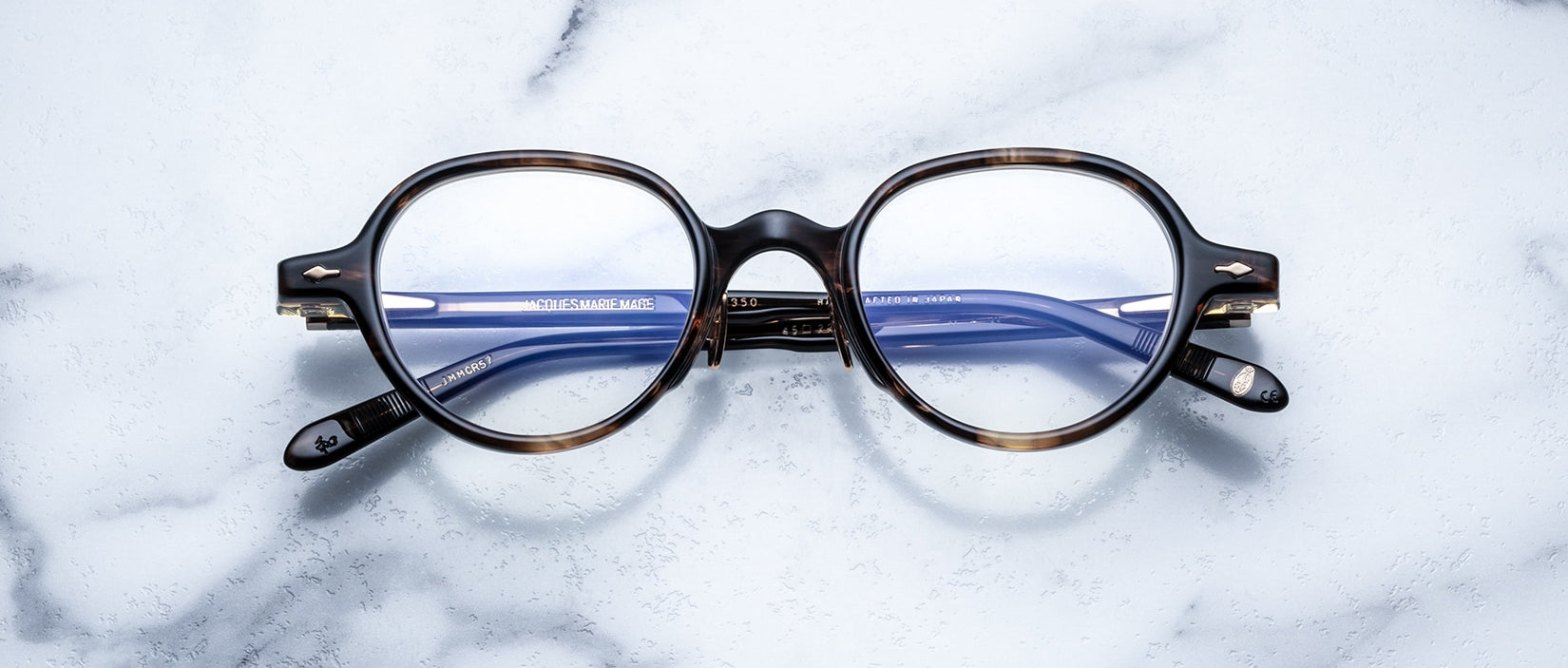 Jacques Marie Mage The Clark round eyeglasses with blue lenses, viewed from above.