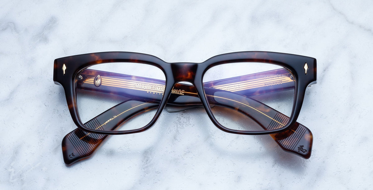 Jacques Marie Mage Molino rectangular tortoiseshell eyeglasses with gold-detailed arms, top-down view.
