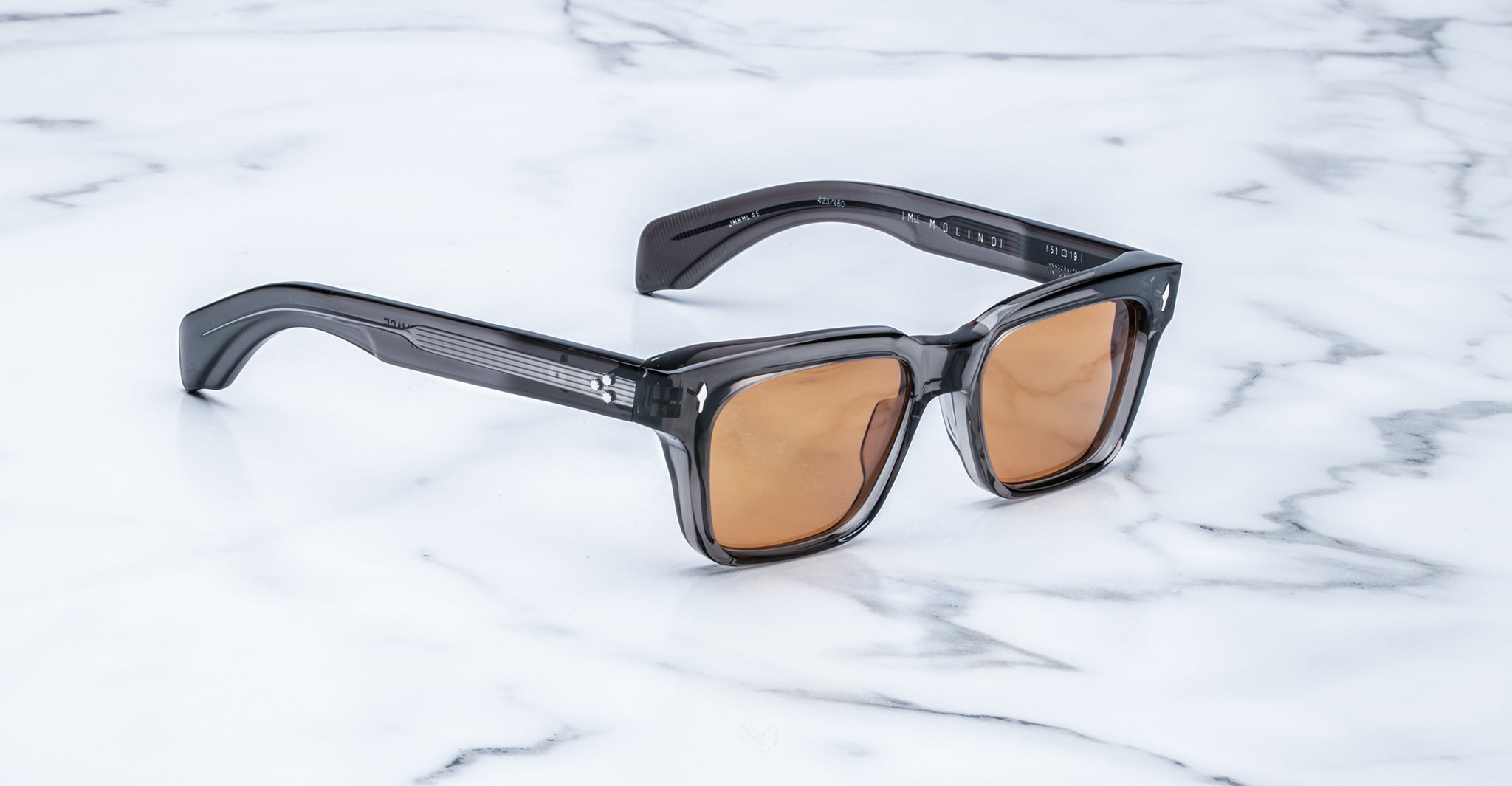 Jacques Marie Mage Molino sunglasses with thick gray translucent frames and brown lenses, viewed from above.