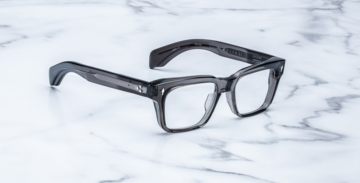 Jacques Marie Mage Molino eyeglasses, thick-rimmed and square with dark translucent frames, shown from above.
