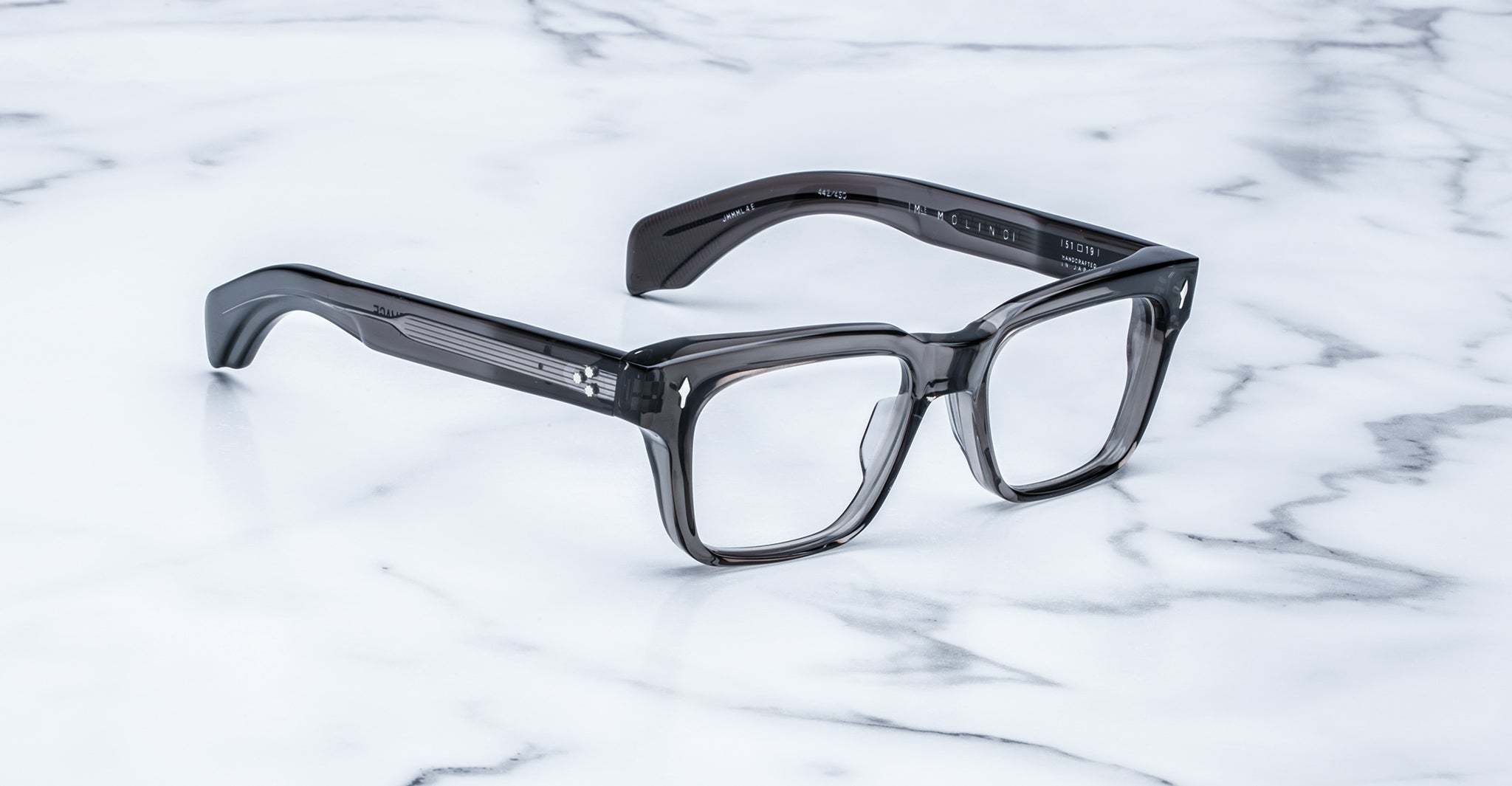Jacques Marie Mage Molino eyeglasses, thick-rimmed and square with dark translucent frames, shown from above.