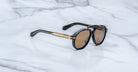 Jacques Marie Mage 1991 sunglasses with gold accents and brown lenses, shown from above, display the brand and model clearly.