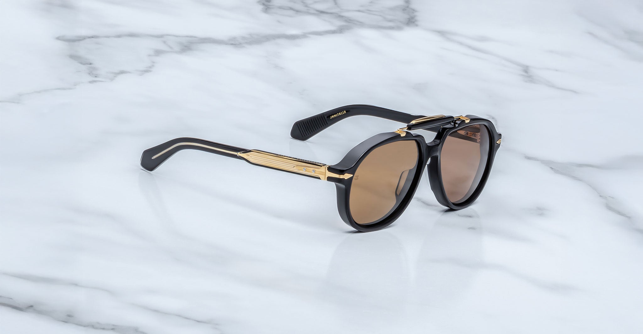 Jacques Marie Mage 1991 sunglasses with gold accents and brown lenses, shown from above, display the brand and model clearly.
