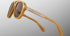 Close-up of Jacques Marie Mage 1991 sunglasses, featuring yellow frames, brown lenses with blue light protection, and silver accents.