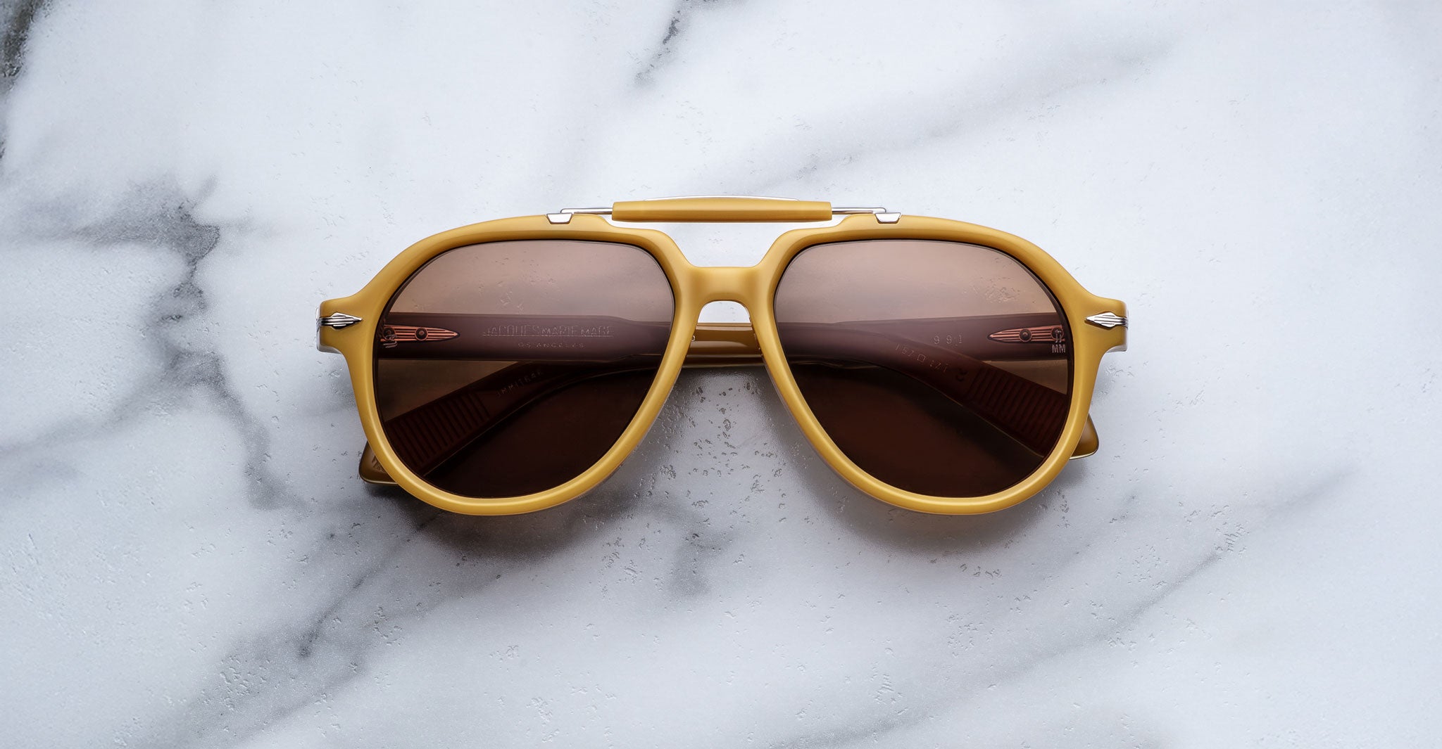 Jacques Marie Mage 1991 aviator sunglasses with brown lenses and yellow frames, product shown from above.