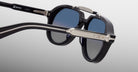 Close-up of Jacques Marie Mage 1991 black sunglasses with blue lenses and silver accents on the temples.