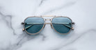 Jacques Marie Mage 755M aviator sunglasses with blue-tinted lenses and a metal frame, viewed from above.