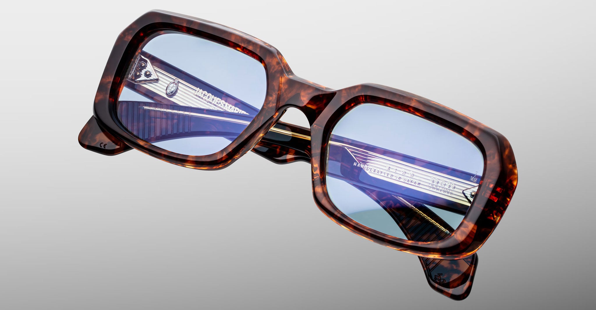 Jacques Marie Mage Aldo square eyeglasses with blue-tinted lenses shown from the front.