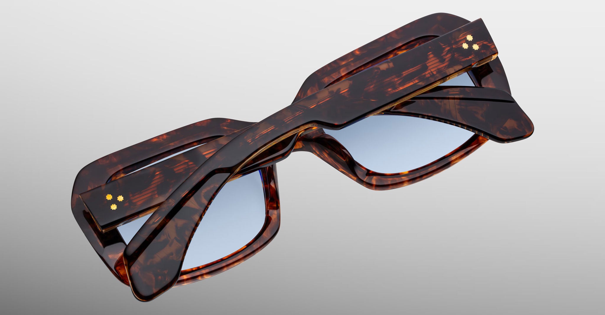 Jacques Marie Mage Aldo sunglasses with twisted tortoiseshell frame and light blue lenses, shown from a front angle.